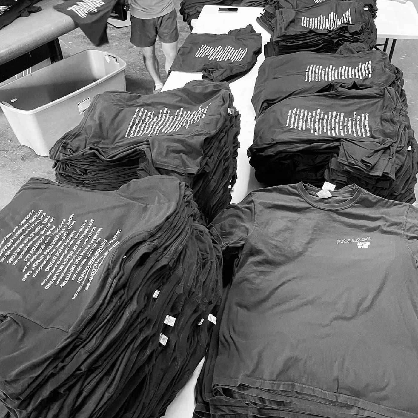Stacks of finished screen printed dark grey shirts sorted for packing