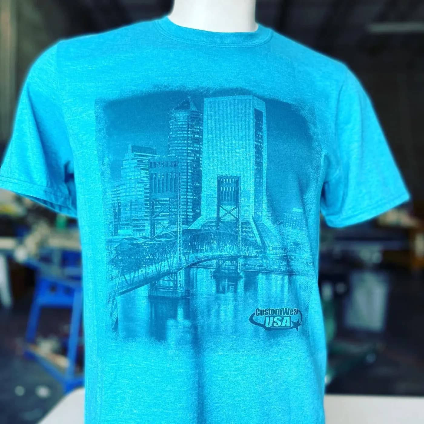 Bright blue t-shirt screen printed with a Jacksonville skyline and bridge design